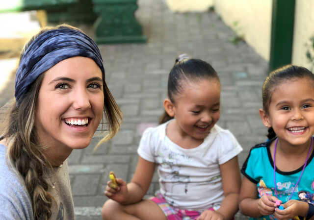 volunteer coloring with young children on a global x journey