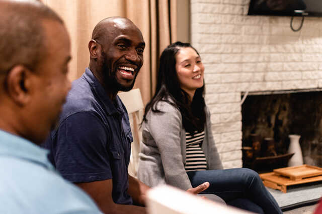 small group leaders smiling at group in living room