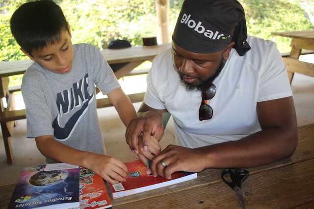 young man working with a child on a global(x) mission trip