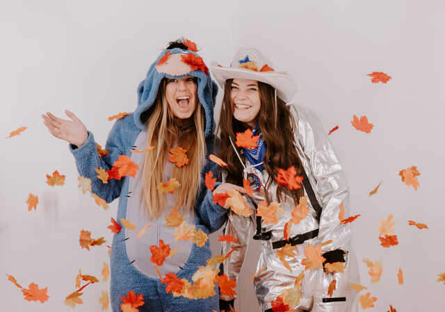 young women in costumes in a fall themed photobooth