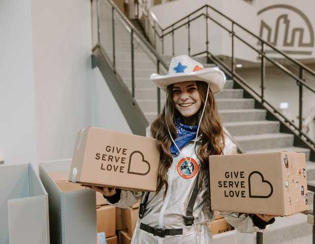 Student holding Give Serve Love boxes