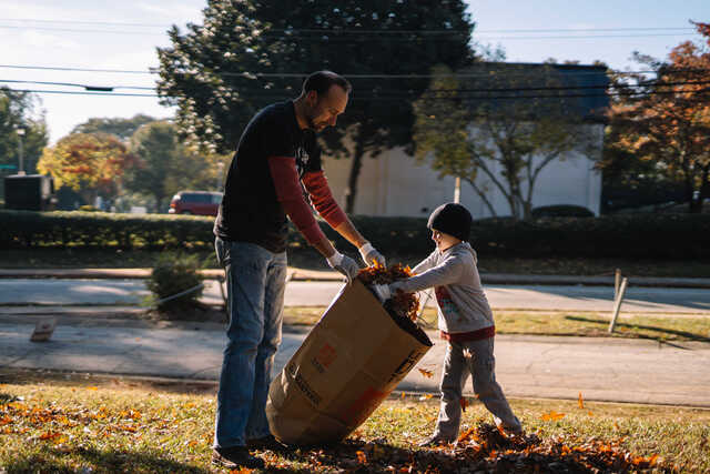 boy and man raking leaves